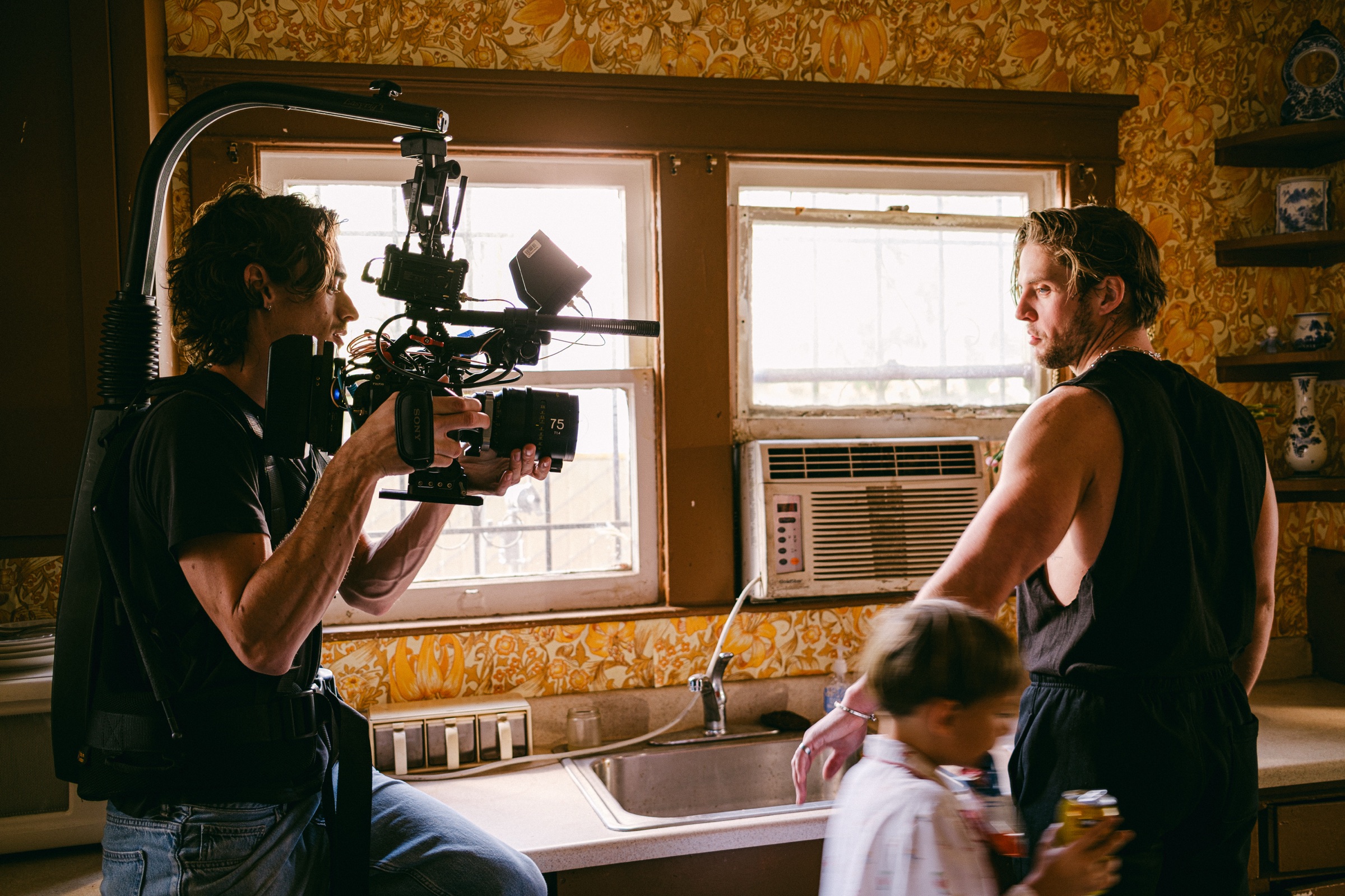 Reed Calder operating a handheld camera rig on a kitchen set.