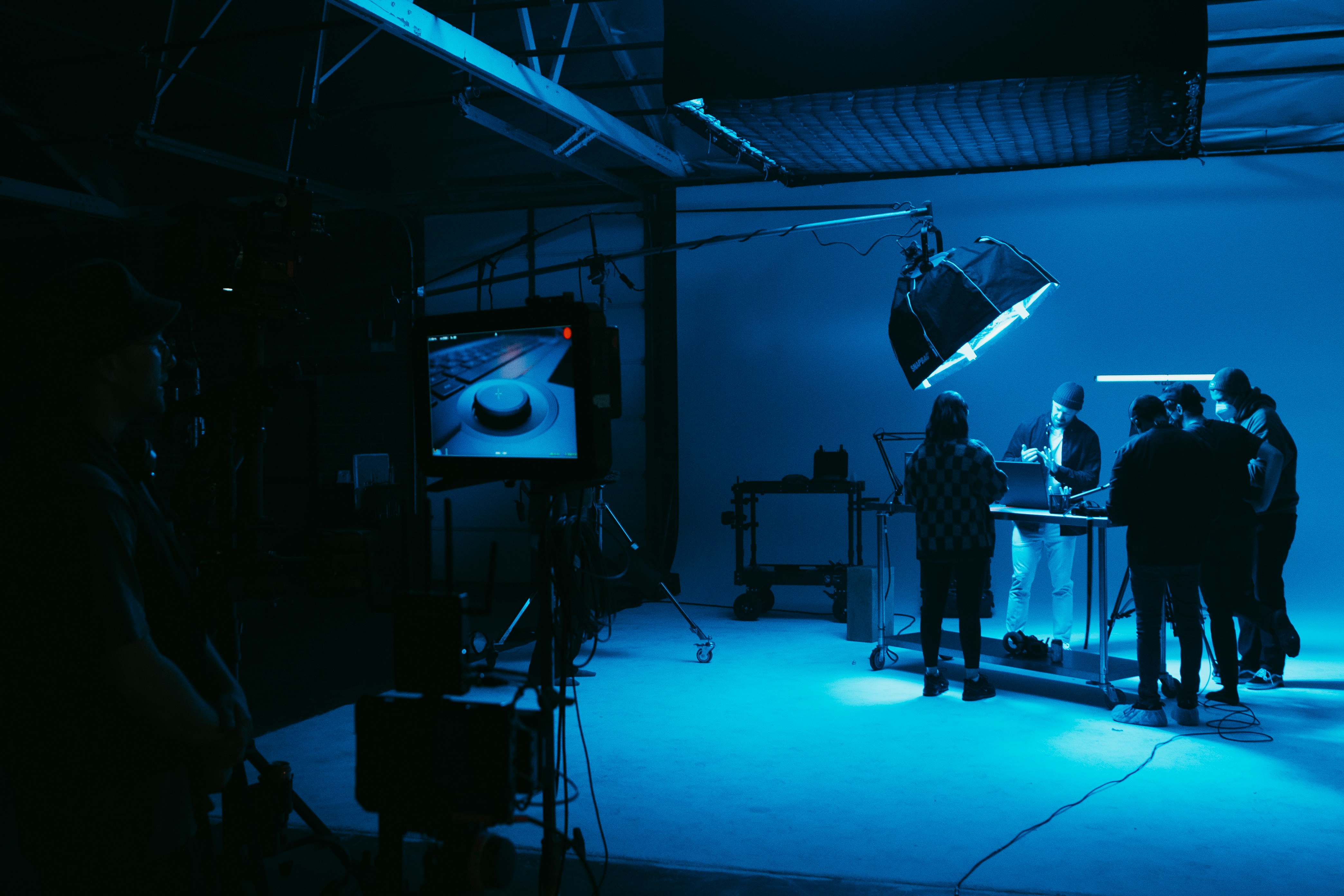 Blue-lit soundstage wide, crew at the cart, DP at the slider.