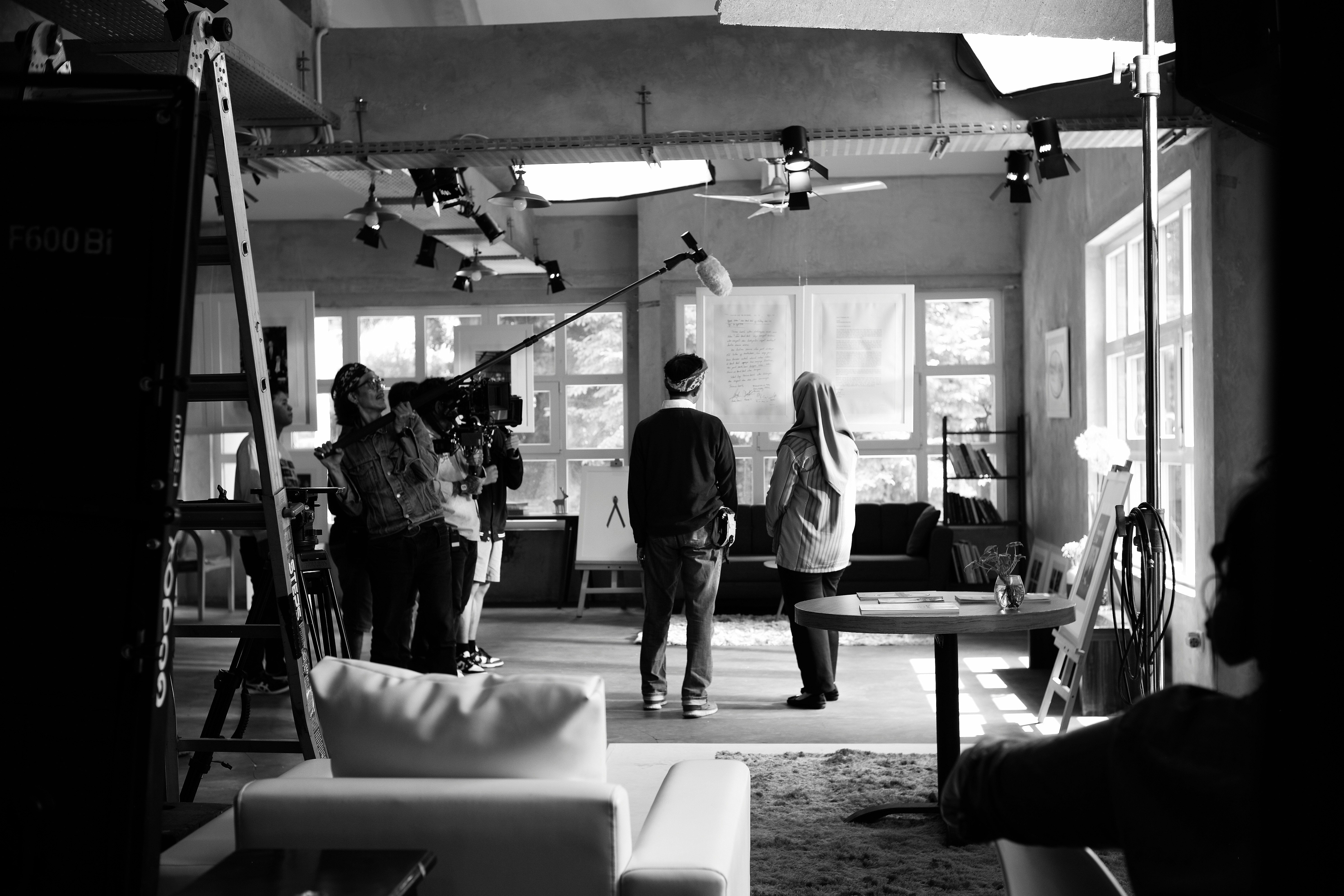 Boom op and crew on a black-and-white interior set.