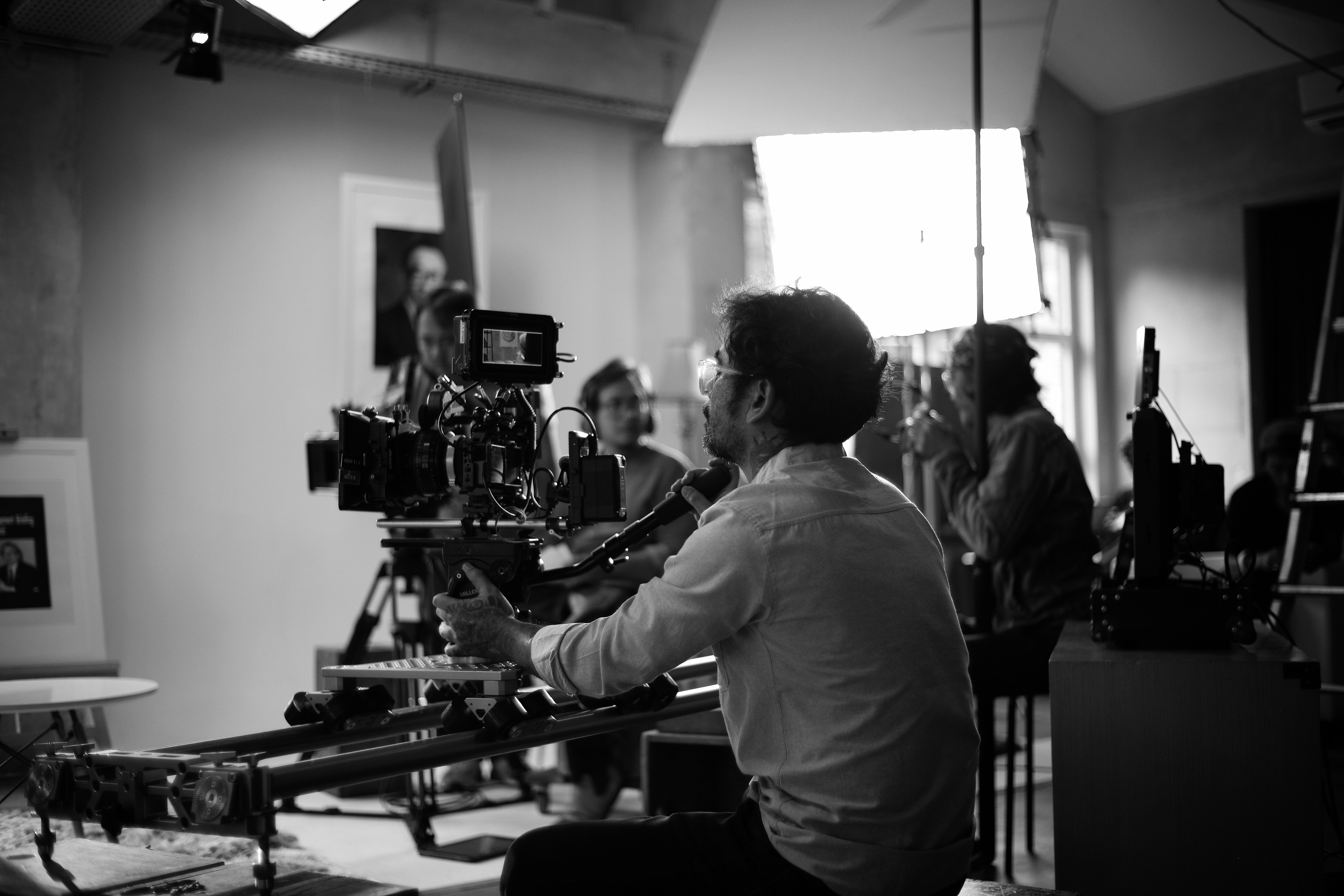 Cinematographer at the slider, black-and-white set still.