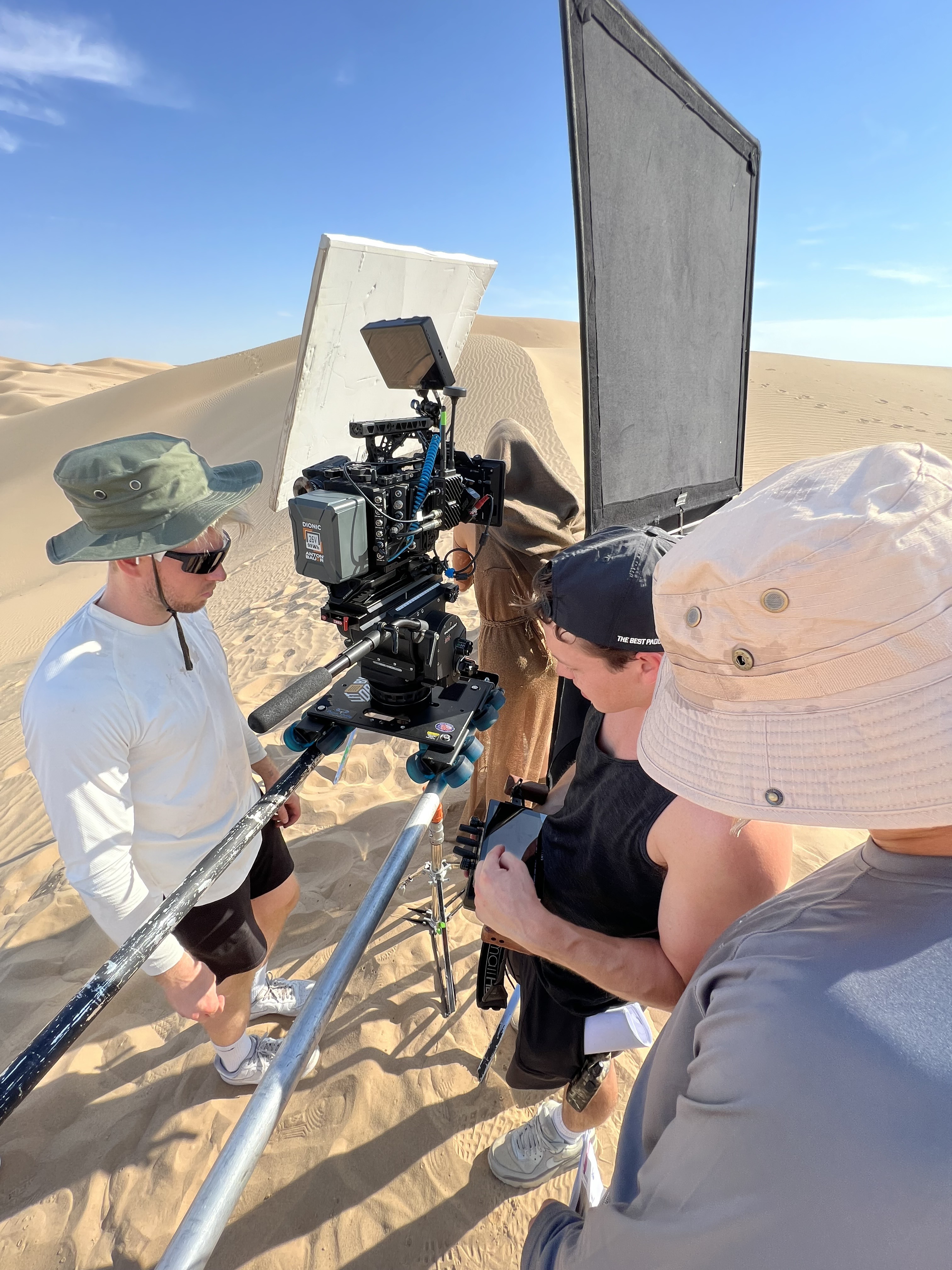 Slider rig set up on a sand dune, camera and reflector ready.