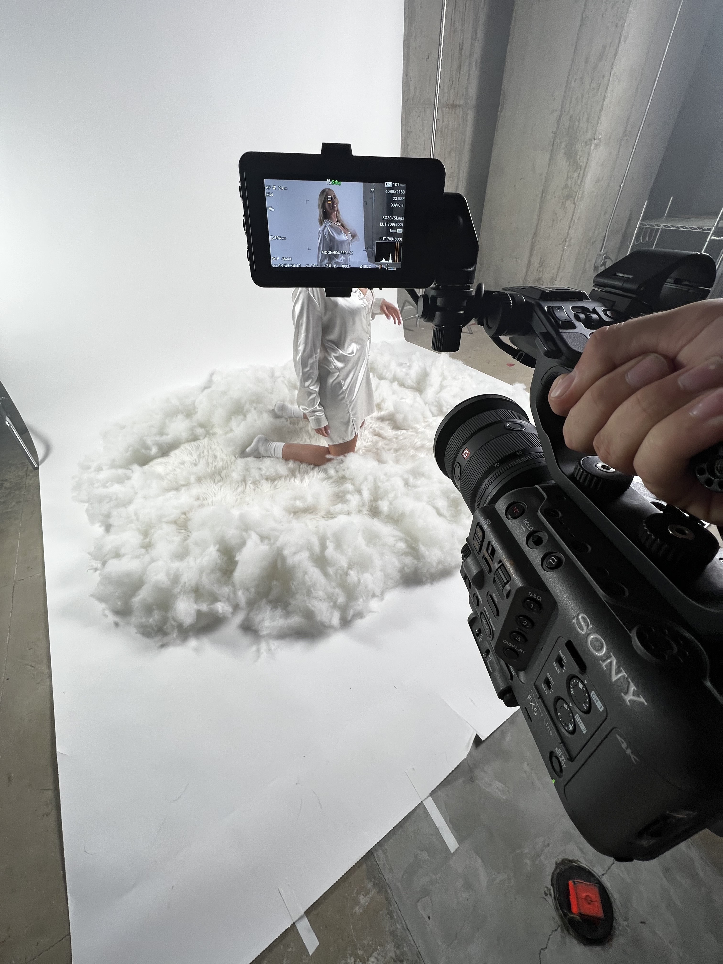 Sony FX6 viewfinder on a fashion commercial set, talent on cloud bed.