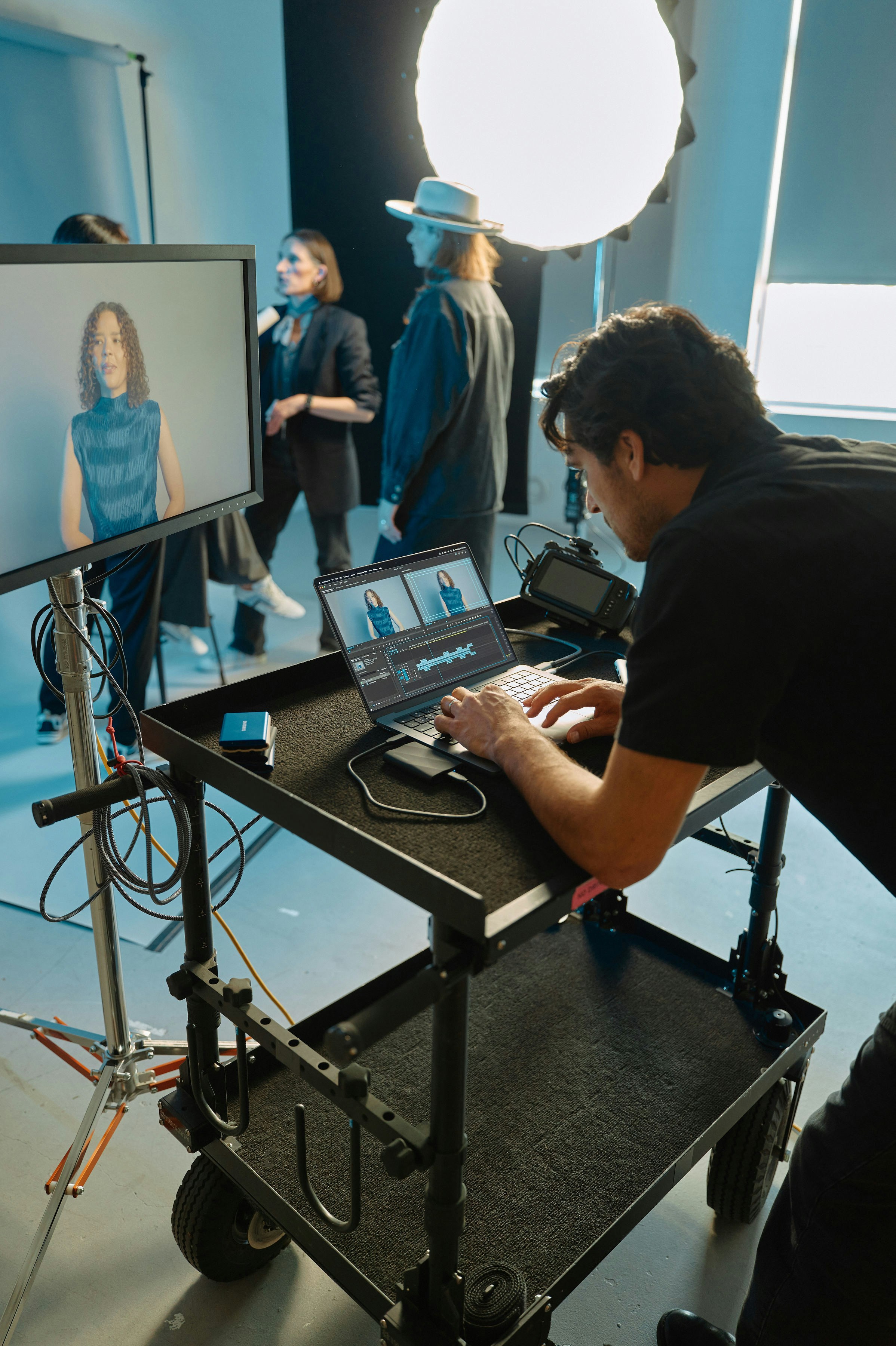 DIT cart, editor reviewing takes between setups.